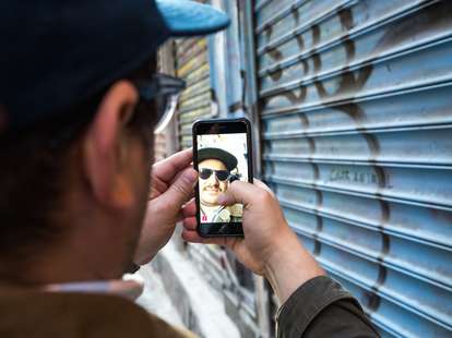 Man snapchatting by graffiti 