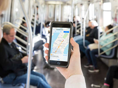 woman holding iPhone looking at Apple Maps