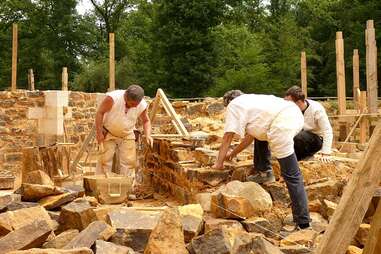 Men in reenactment costumes constructing castle