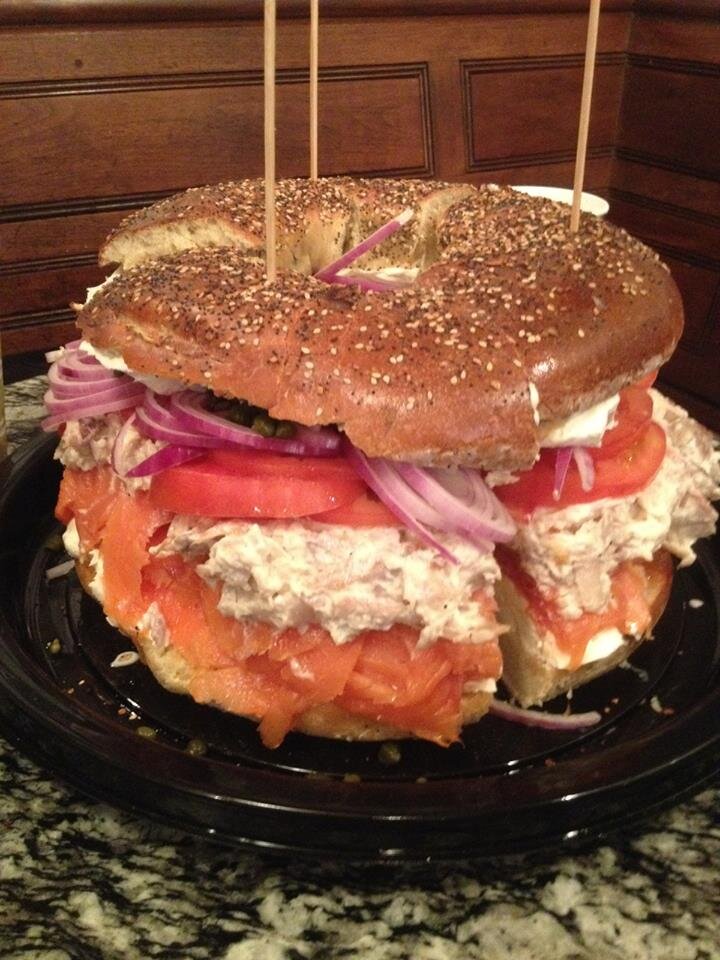 Large bagel crammed with lox, cream cheese, and tomato slices