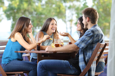 man and three woman at lunch outside