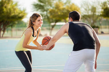 man and woman playing basketball