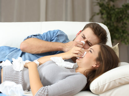 man and woman sick together on couch