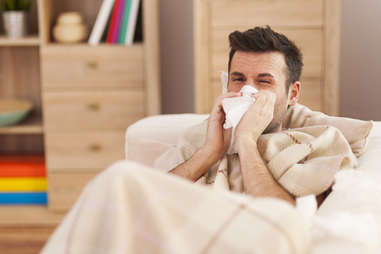 man blowing his nose sick