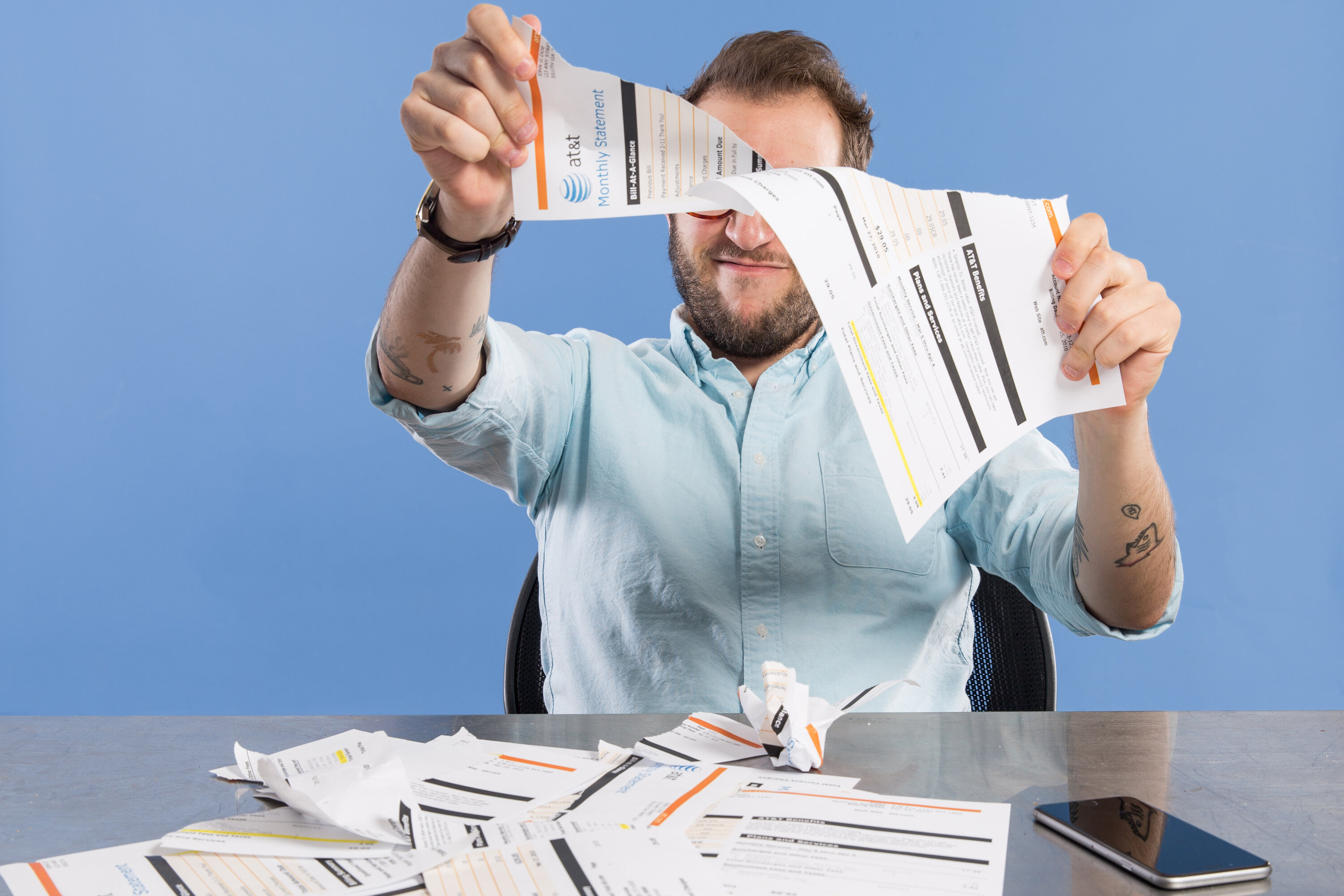 man tearing up phone bills