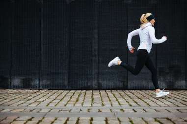 woman jogging on a cobble stone street