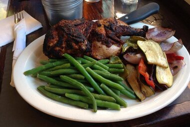 BBQ chicken, green beans, and grilled veggies on a plate