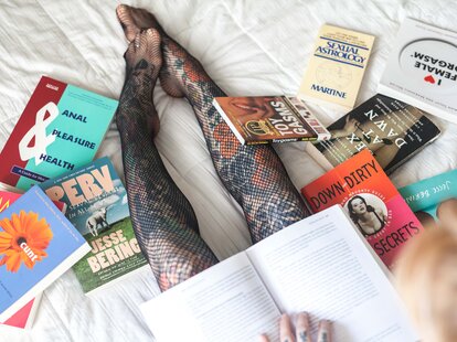 Elle Stranger sitting on bed with books