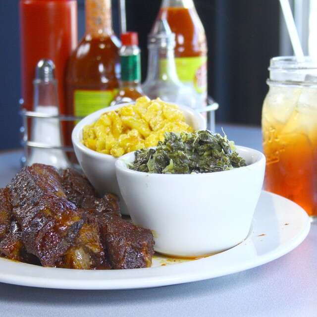 BBQ, collard greens, and mac ‘n cheese served on a plate
