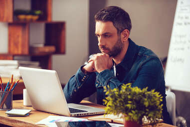 a man looking at his computer and working concentrating intensely