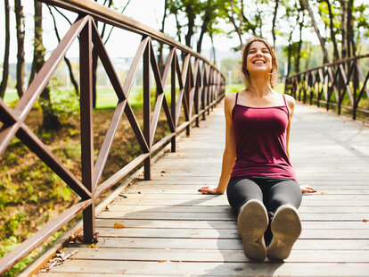 a woman relaxing sitting sunbathing on a bridge vitamin d