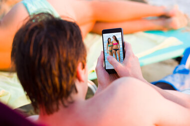 man looking at pictures of women on his phone