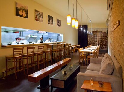 Empty interior of Ani with chefs behind bar