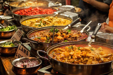 spicy Indian dishes being served in pots and pans