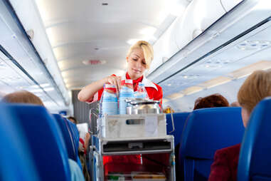 airline flight attendant with food and drink cart