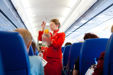 flight attendant demonstrating oxygen mask