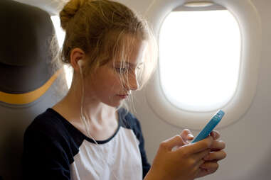 woman on an airplane with her cellphone