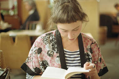 Girl reading a book at a cafe