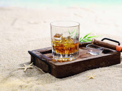 Glass of rum on a tray on a beach