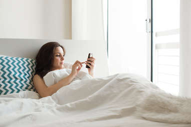 woman texting in bed long distance relationships