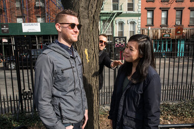 Couple in a park with a pervert watching them behind a tree