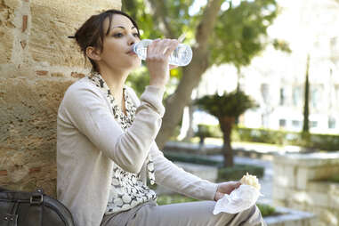 woman drinking from a plastic water bottle