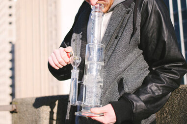 man smoking marijuana from a water pipe