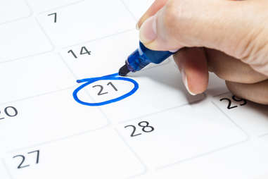 close up of person marking a date on a calendar