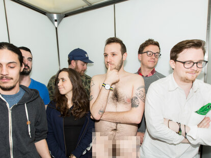 Naked man with blurred crotch in crowded elevator