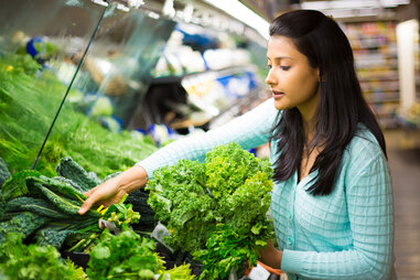 woman shopping for vegetables at a grocery store