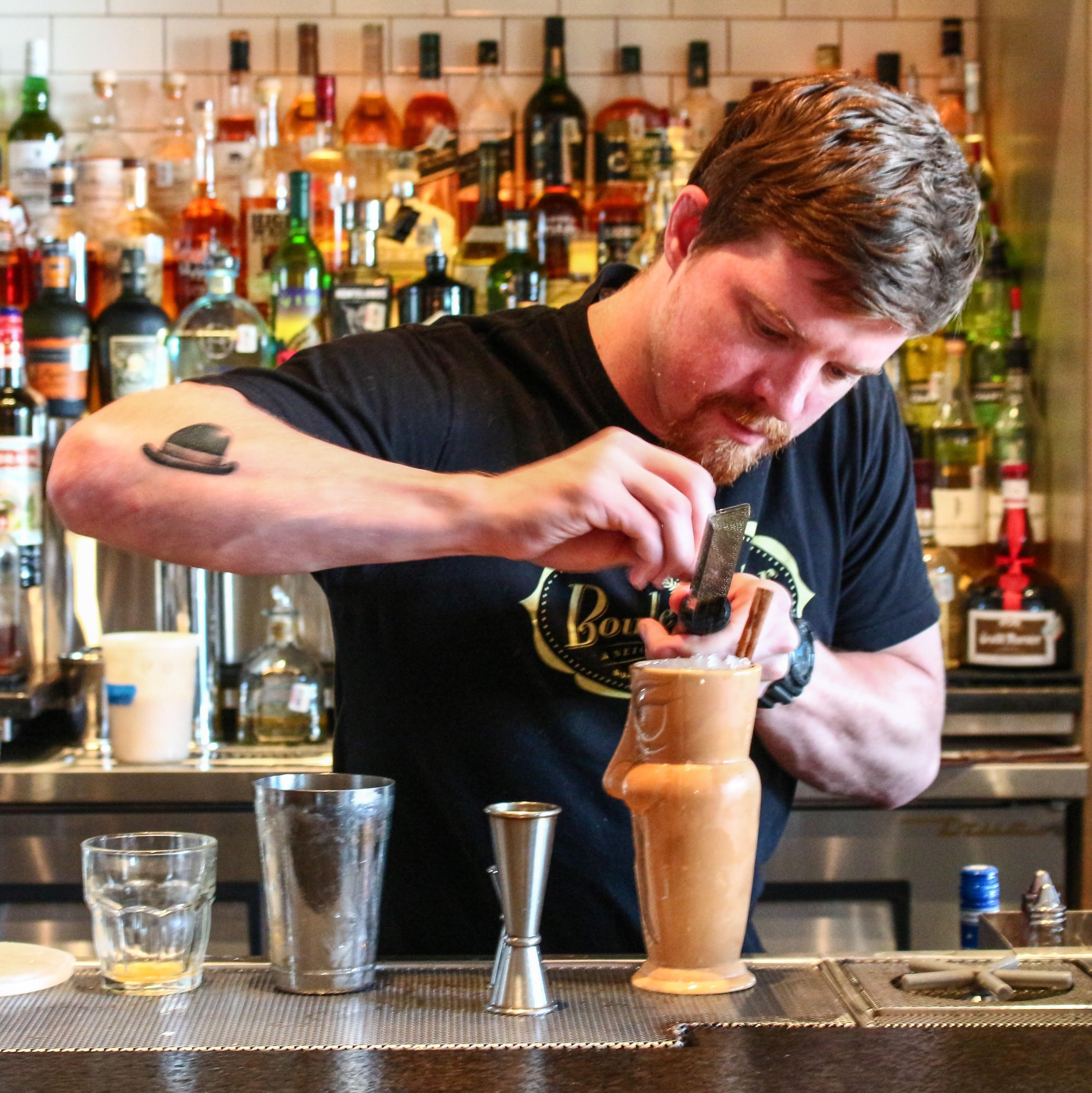 Eddie Eakin placing garnish on cocktail