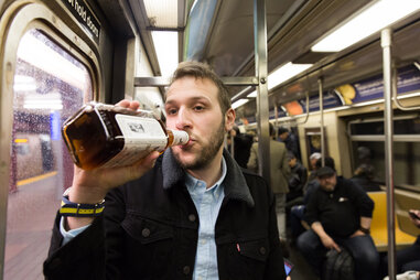 Man drinking whiskey within NYC subway