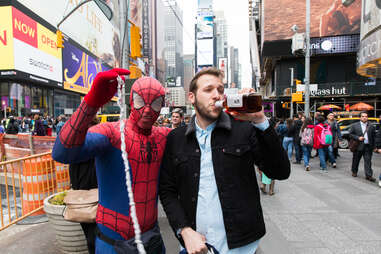 Man drinking whiskey with Times Square Spiderman