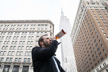 Man drinking in front of Empire State Building