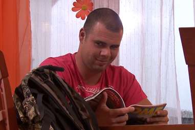 Man reading a magazine and looking aroused