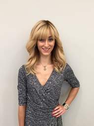 blonde woman in front of a wall