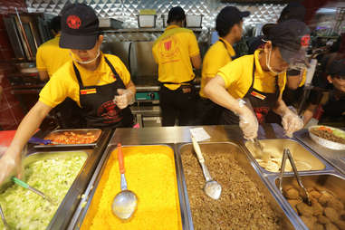 Woman working behind Halal Guys counter