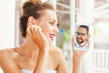 woman looking at man on smartphone