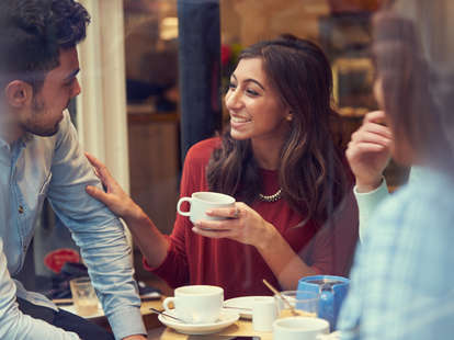 girl touching guy on the arm at a coffee shop