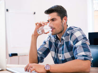 man drinking water and listening to music