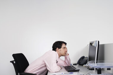 Business man slouched in front of computer