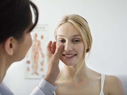 Dermatolagist checking girl’s skin