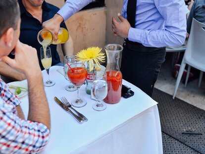 men at brunch drinking mimosas and bloody marys