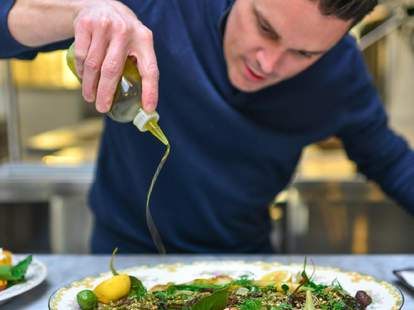 Spoon & Stable thrillist salad guy in blue shirt pouring olive oil