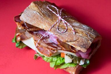 goose the market sandwich tied up red background