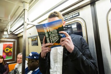 guy reading jonathan franzen on subway