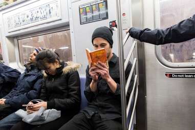 guy reading catcher in the rye on subway