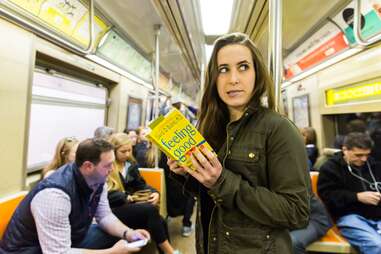 girl reading self help book on subway