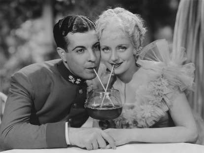 Vintage photo of couple on dating sharing drink
