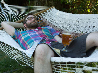 man in hammock with beer